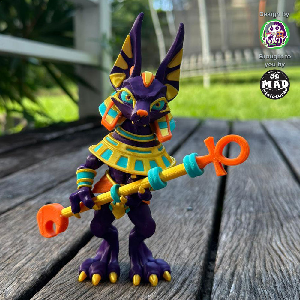 Articulated Anubis figure holding a golden staff with both hands
