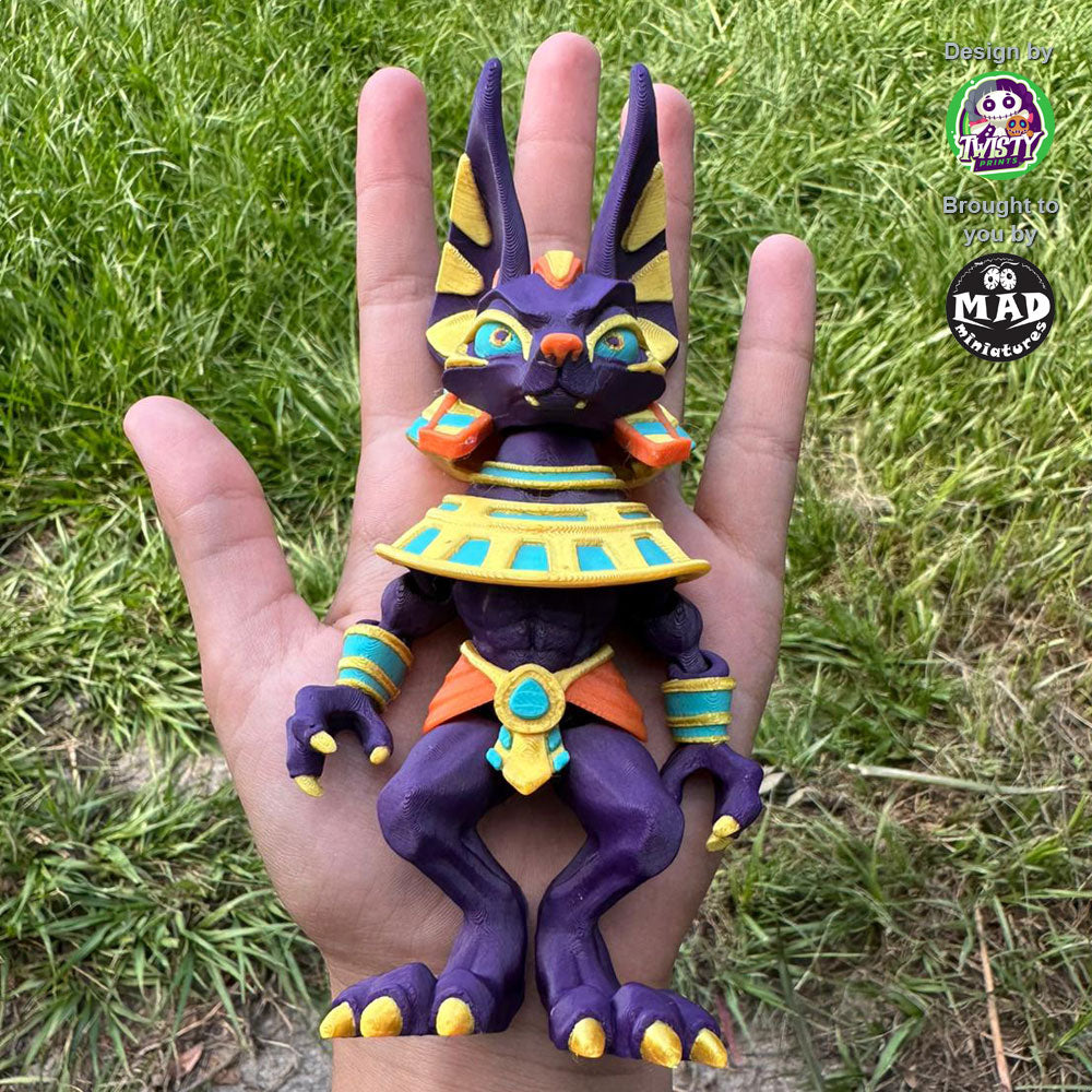 Articulated Anubis figure held in a person’s hand, showing its size