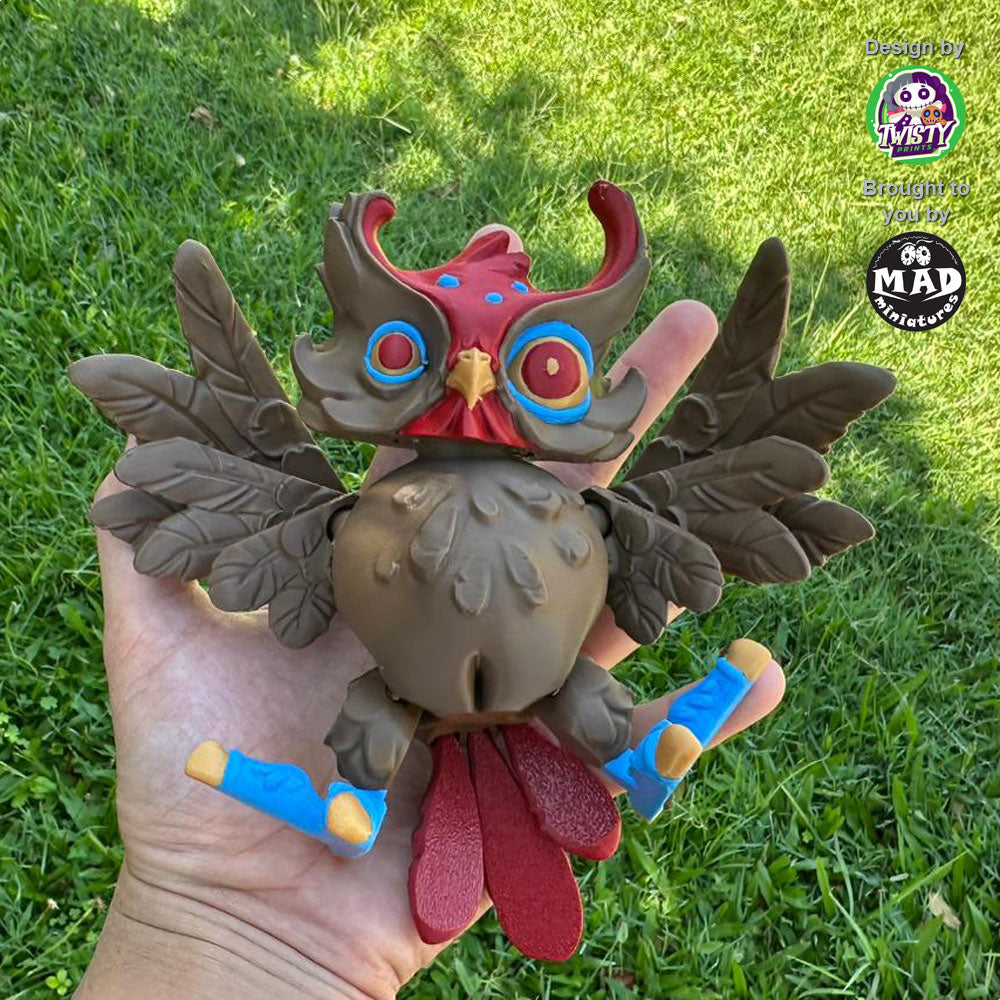 Hypnotic version of the Creepy Owl held in a hand, highlighting its dark brown body, maroon accents, and movable wings and head