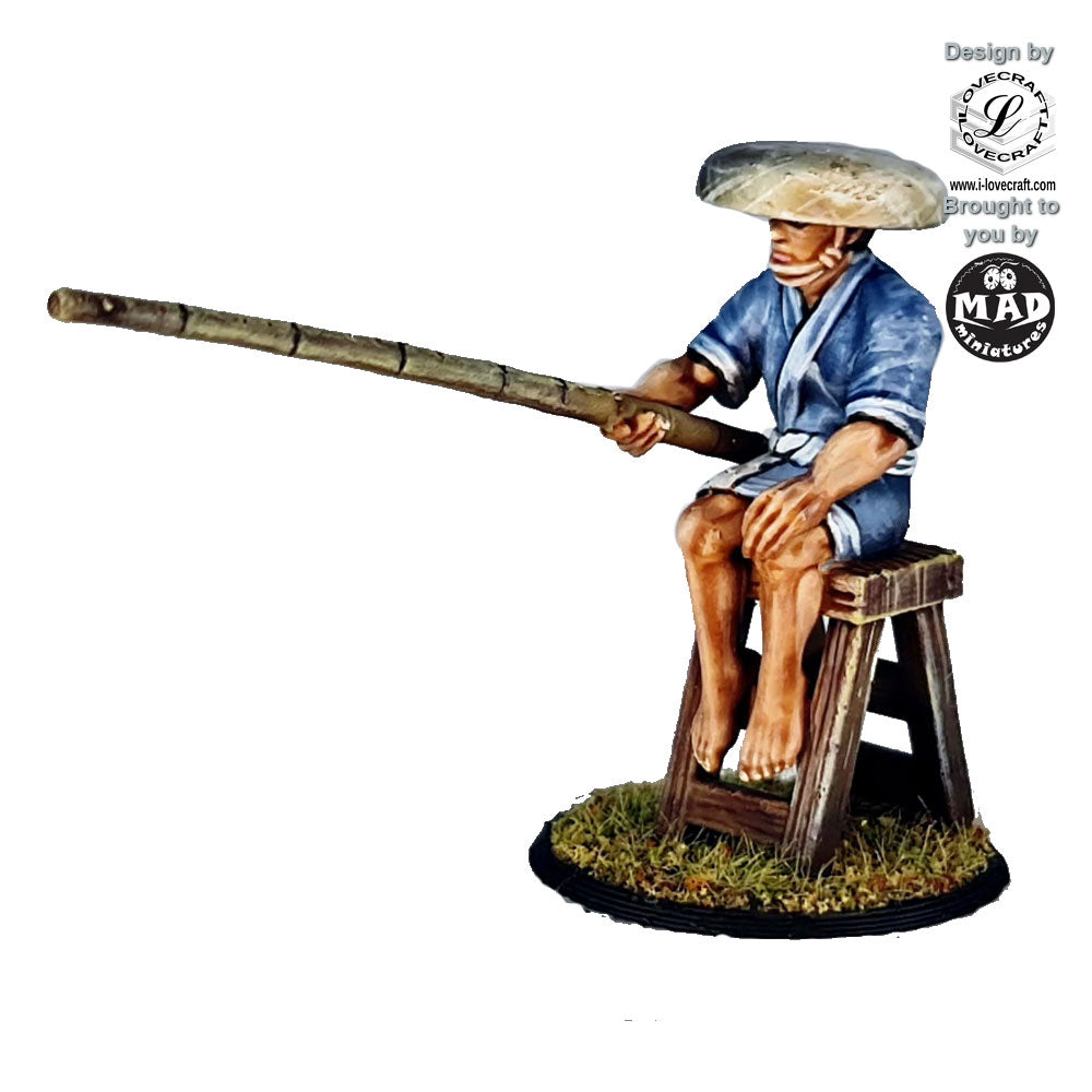 28mm miniature of a seated Edo-period fisherman wearing a straw hat and blue robe, holding a bamboo fishing pole, designed for tabletop gaming and dioramas.