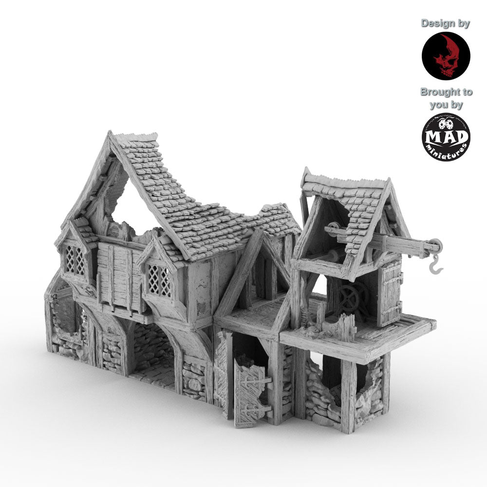 Ruined Warehouse terrain piece from the Helwick campaign. A detailed medieval-style structure with damage and a crane, designed by Terrablocks and made by Mad Miniatures.