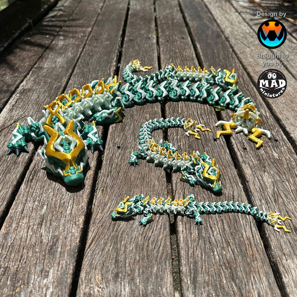 Storm Dragon by Mad Miniatures, designed by Cinderwing. A fully articulated, 3D-printed dragon with metallic green scales, white and gold lightning bolts, and dark grey eyes.