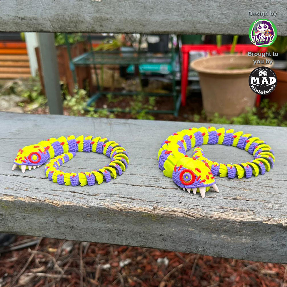 Stuffed Snake (both sizes) curled up on stairs, displaying their colorful, patchwork design and creepy, captivating charm.
