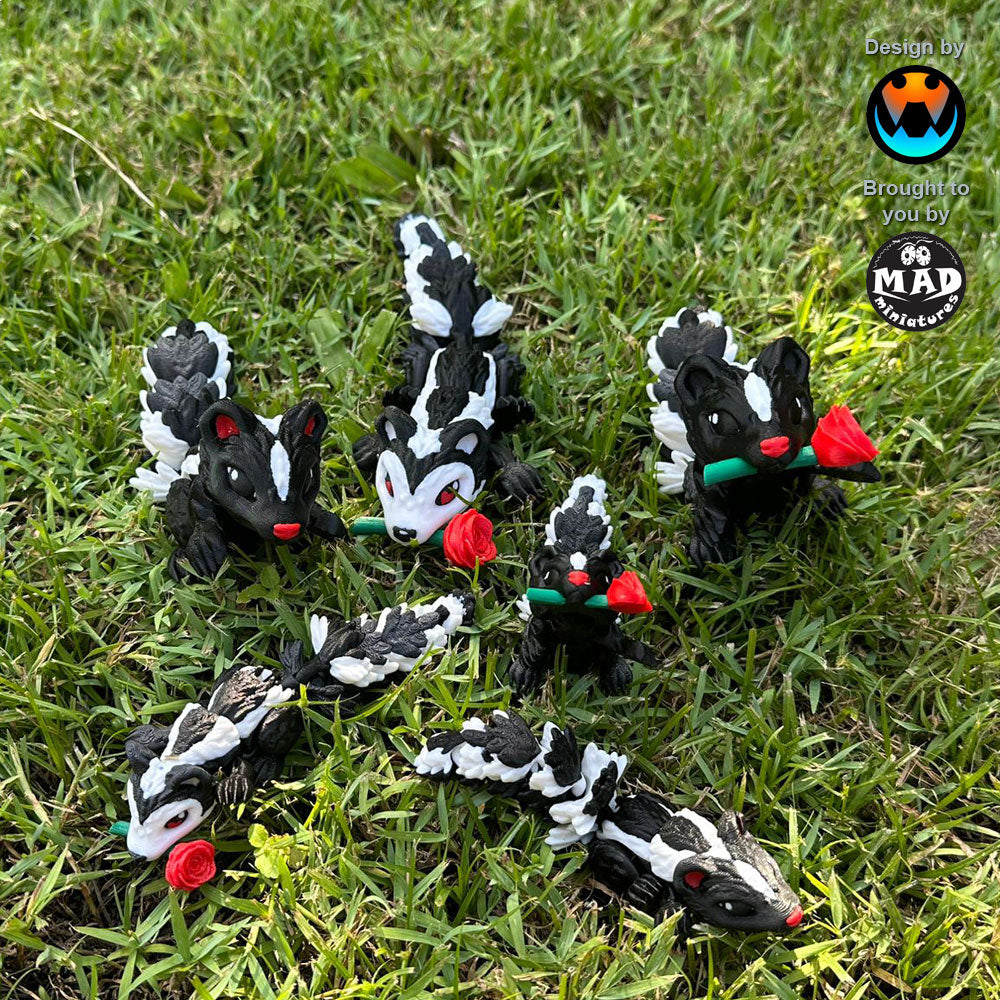 Six red Sweetheart Skunks from Mad Miniatures, designed by Cinderwing, sitting on grass, with and without roses, in small and normal sizes. Fully articulated and charming.