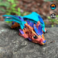 Baby Crystal Wolf Dragon sitting on a rock, its shimmering body and turquoise wings on full display. A magical addition to any fantasy collection.