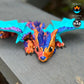 Baby Crystal Wolf Dragon sitting with wings spread, showcasing its shiny bronze/copper body and bright blue/magenta crystals. Fully articulated and adorable.