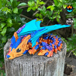 Baby Crystal Wolf Dragon from Mad Miniatures, designed by Cinderwing, sitting on a tree trunk with shimmering bronze/copper body and blue/magenta crystals.