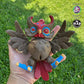 Hypnotic version of the Creepy Owl held in a hand, highlighting its dark brown body, maroon accents, and movable wings and head