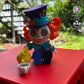 Mad Hatter pouring tea from his teapot, with his wild orange hair spilling from his oversized hat, created by Twisty Prints