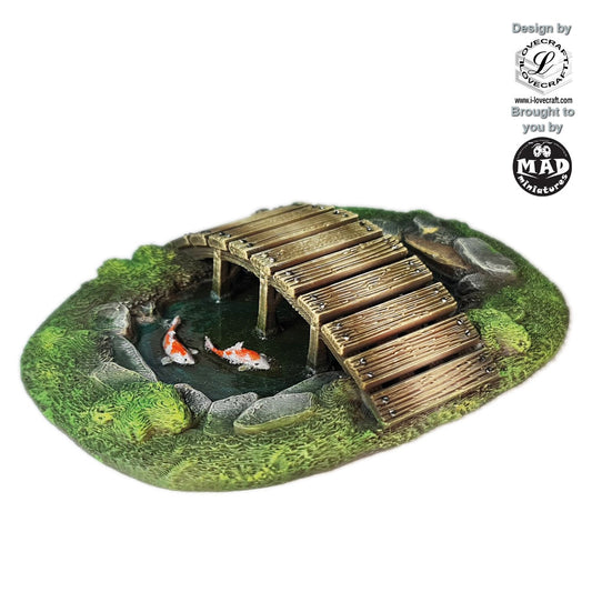Pond with arched wooden bridge and koi fish – Nippon Saga terrain by Iain Lovecraft, made by Mad Miniatures.
