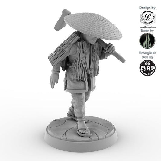 32 mm miniature of a Japanese farmer wearing a straw hat and cloak, carrying a hoe – Nippon Saga model by Mad Miniatures.