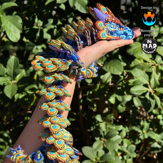 Peacock Dragon by Mad Miniatures – 3D-printed articulated dragon in vibrant peacock colours, coiled around a forearm