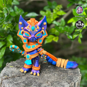 Pharaoh Cat standing on a tree trunk, holding her Egyptian ceremonial staff, with a shimmering blue-purple coat and golden accessories.