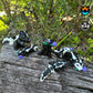 Purple Sweetheart Skunks from Mad Miniatures, designed by Cinderwing, sitting on a fallen tree, featuring all six versions, with and without roses, in small and normal sizes.

